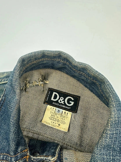 Dolce & Gabbana blue distressed denim jacket with painted details and pins.