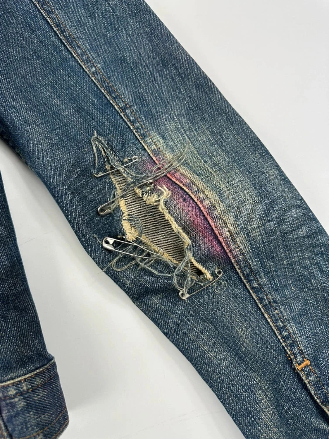 Dolce & Gabbana blue distressed denim jacket with painted details and pins.