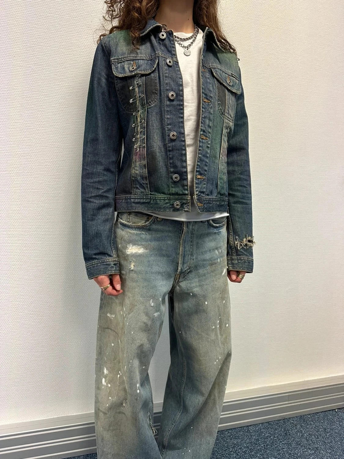 Dolce & Gabbana blue distressed denim jacket with painted details and pins.