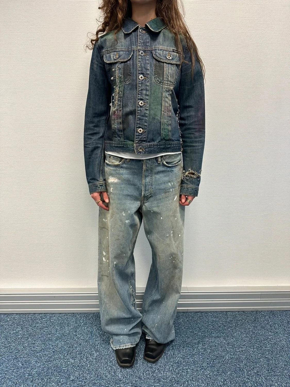 Dolce & Gabbana blue distressed denim jacket with painted details and pins.