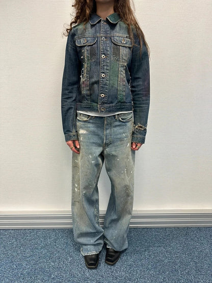 Dolce & Gabbana blue distressed denim jacket with painted details and pins.