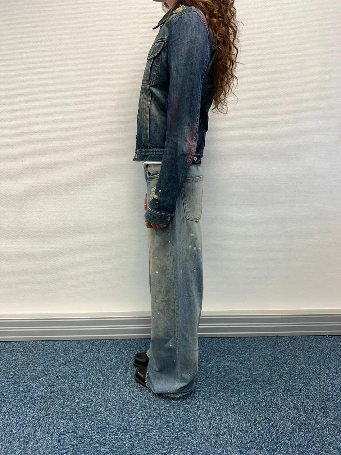 Dolce & Gabbana blue distressed denim jacket with painted details and pins.