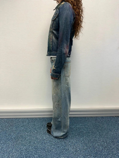 Dolce & Gabbana blue distressed denim jacket with painted details and pins.