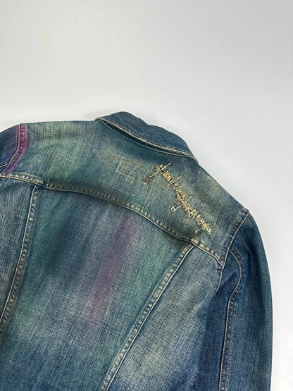 Dolce & Gabbana blue distressed denim jacket with painted details and pins.