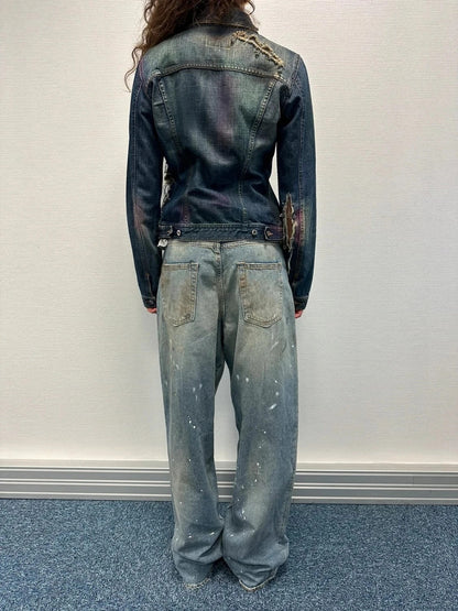 Dolce & Gabbana blue distressed denim jacket with painted details and pins.