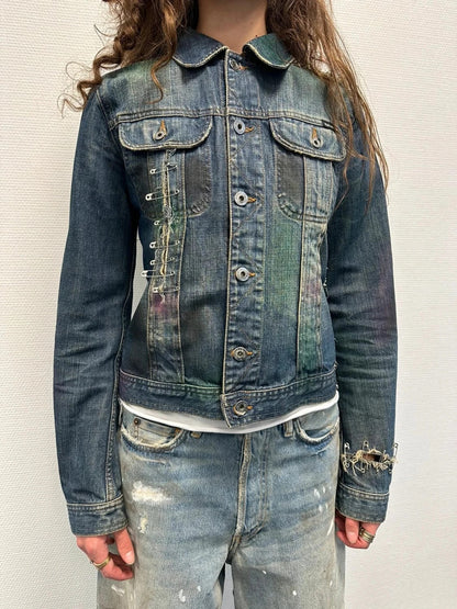 Dolce & Gabbana blue distressed denim jacket with painted details and pins.