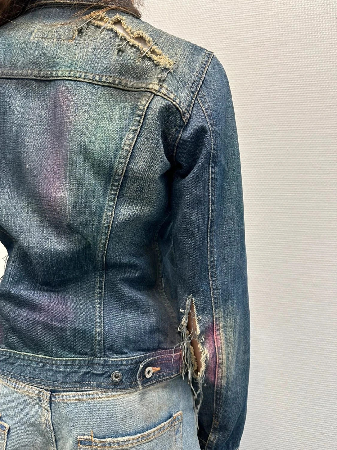 Dolce & Gabbana blue distressed denim jacket with painted details and pins.