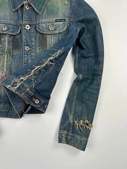 Dolce & Gabbana blue distressed denim jacket with painted details and pins.