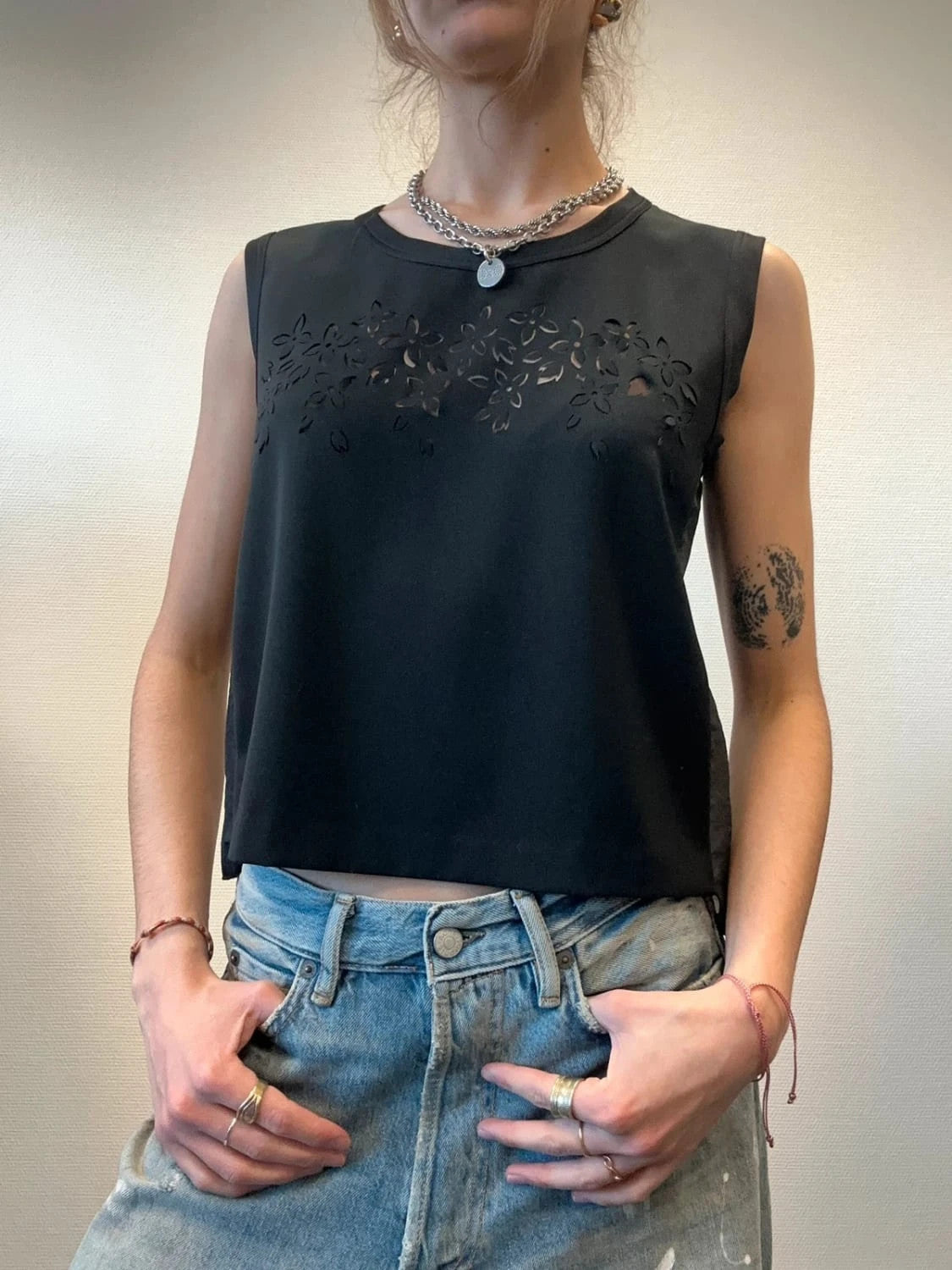 Marithé Francois Girbaud black tank top with floral laser cut details and sheer back.