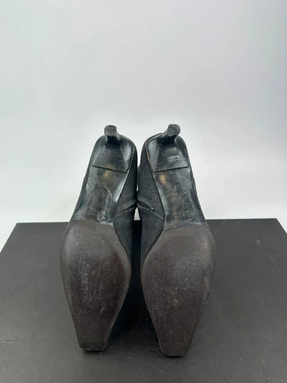Gucci black monogram knee-high boots with pointed toe and logo pattern.