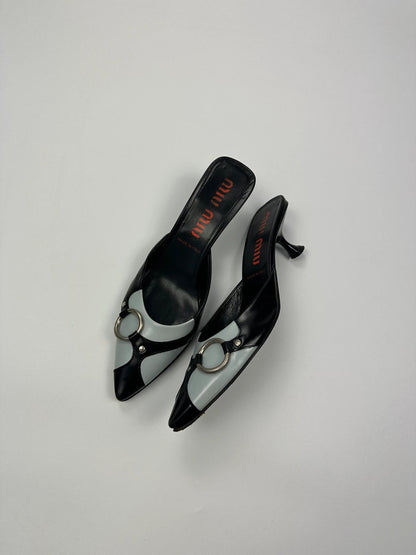 Miu Miu black and blue patent leather pumps with pointy toe and logo detail.