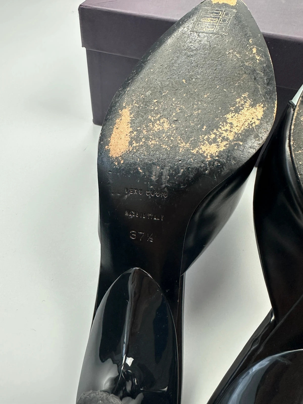 Miu Miu black and blue patent leather pumps with pointy toe and logo detail.
