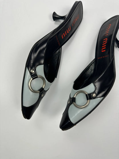 Miu Miu black and blue patent leather pumps with pointy toe and logo detail.