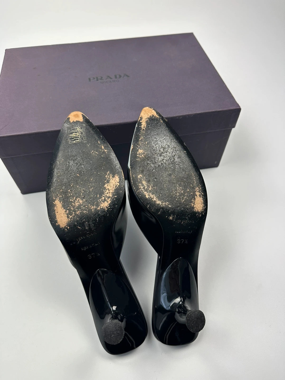Miu Miu black and blue patent leather pumps with pointy toe and logo detail.