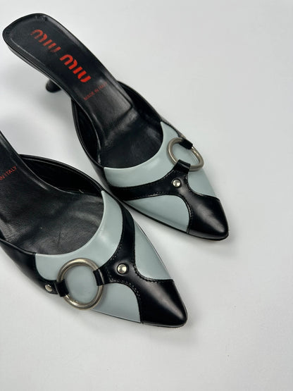 Miu Miu black and blue patent leather pumps with pointy toe and logo detail.