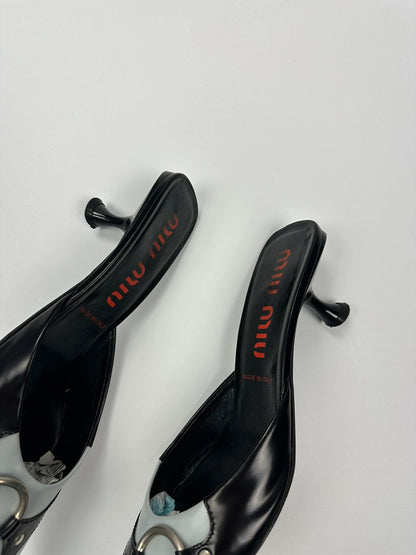 Miu Miu black and blue patent leather pumps with pointy toe and logo detail.