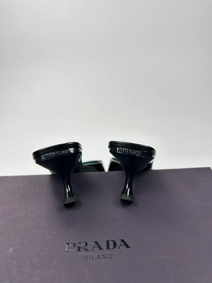 Miu Miu black and blue patent leather pumps with pointy toe and logo detail.