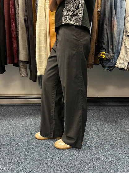 Prada grey wide-leg dress pants with subtle logo detail and luxurious wool material.
