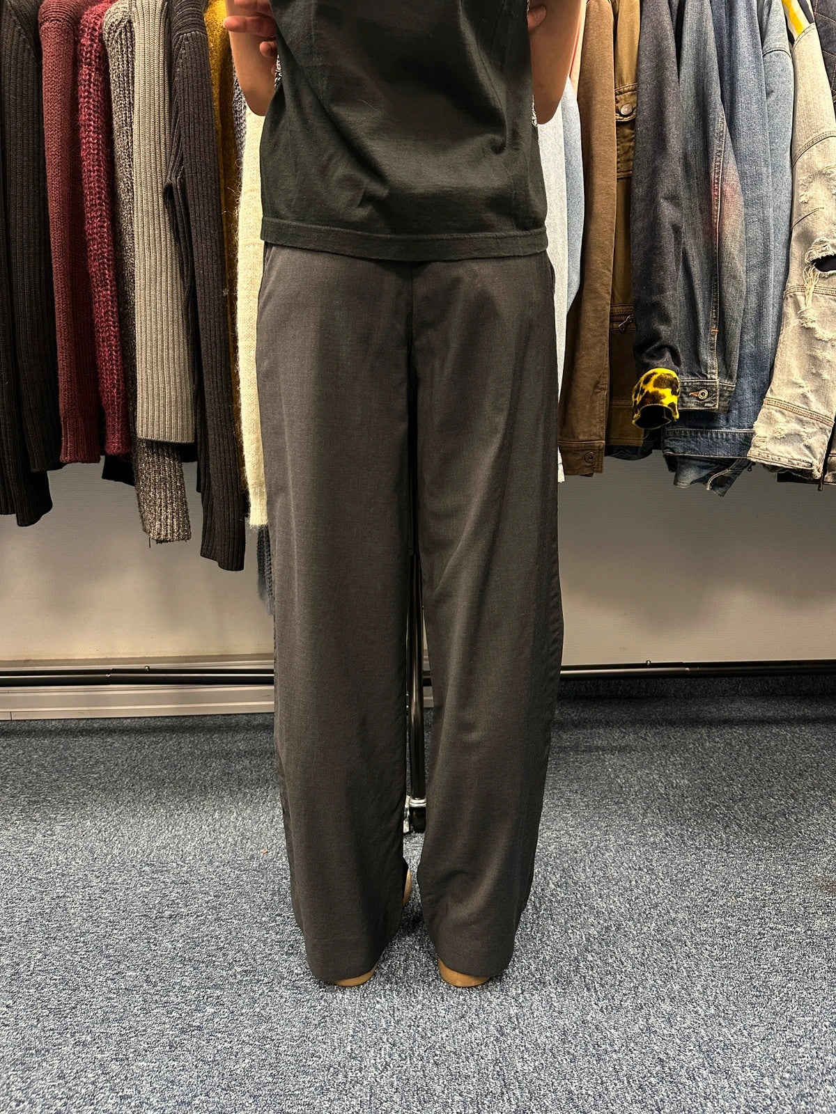 Prada grey wide-leg dress pants with subtle logo detail and luxurious wool material.