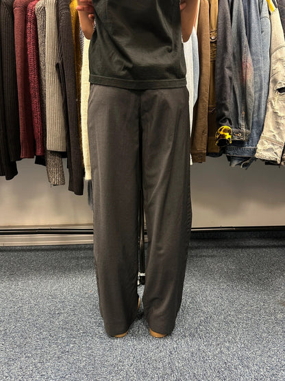 Prada grey wide-leg dress pants with subtle logo detail and luxurious wool material.