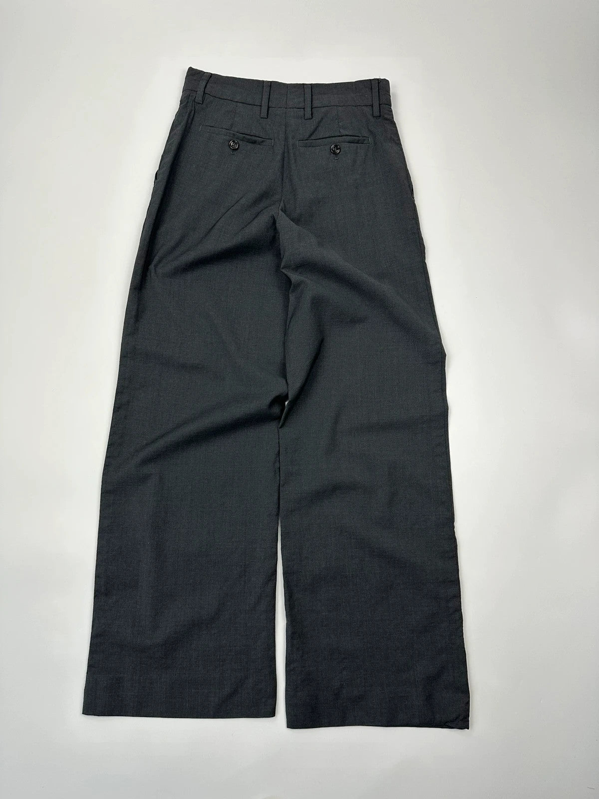 Prada grey wide-leg dress pants with subtle logo detail and luxurious wool material.
