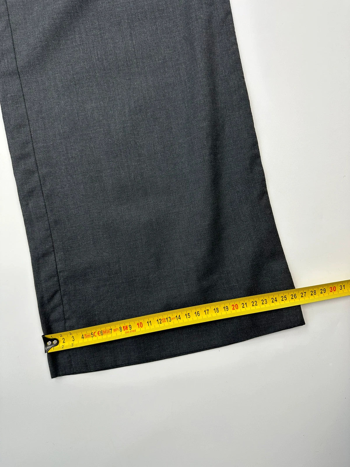 Prada grey wide-leg dress pants with subtle logo detail and luxurious wool material.