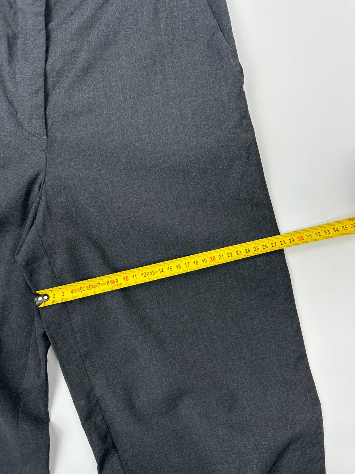 Prada grey wide-leg dress pants with subtle logo detail and luxurious wool material.