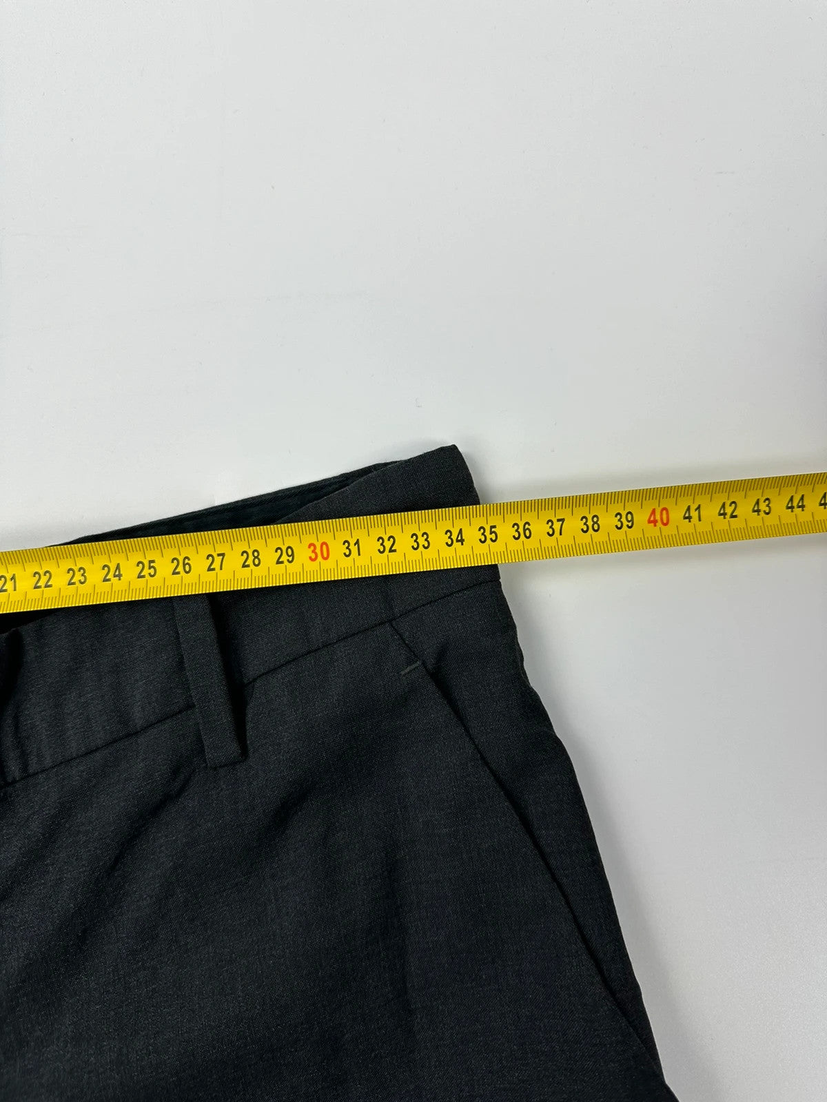 Prada grey wide-leg dress pants with subtle logo detail and luxurious wool material.
