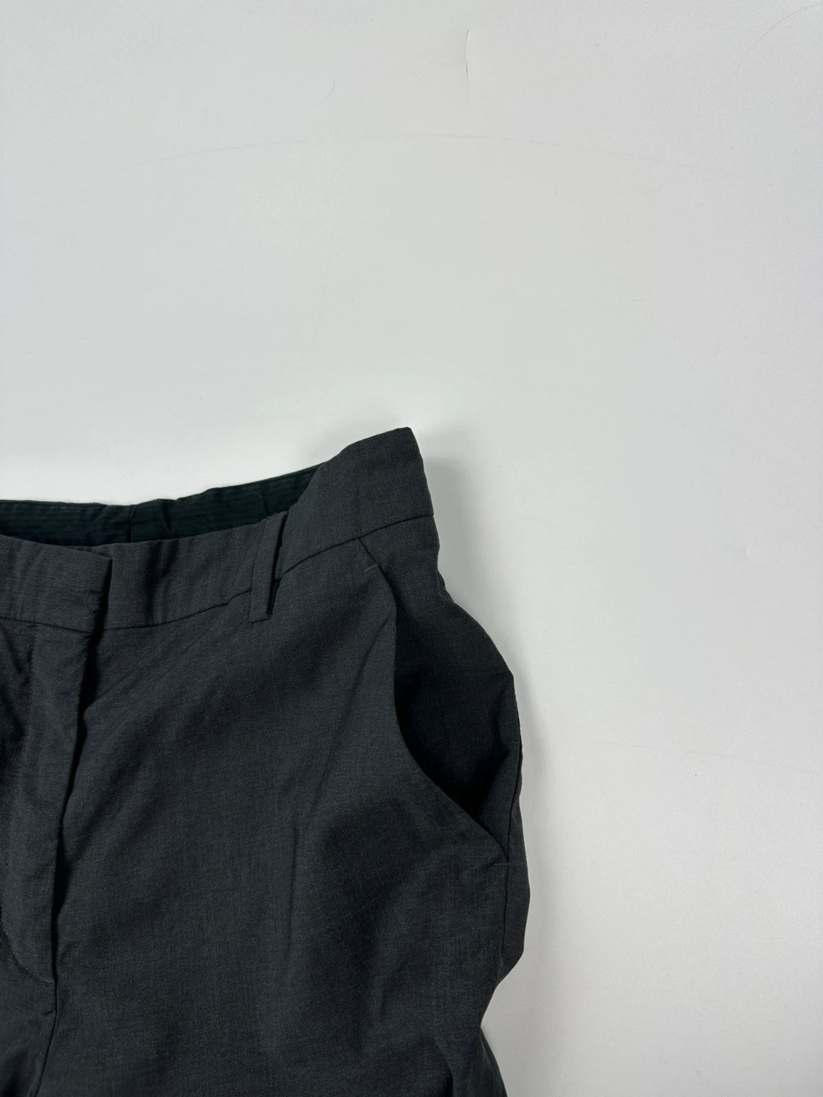 Prada grey wide-leg dress pants with subtle logo detail and luxurious wool material.