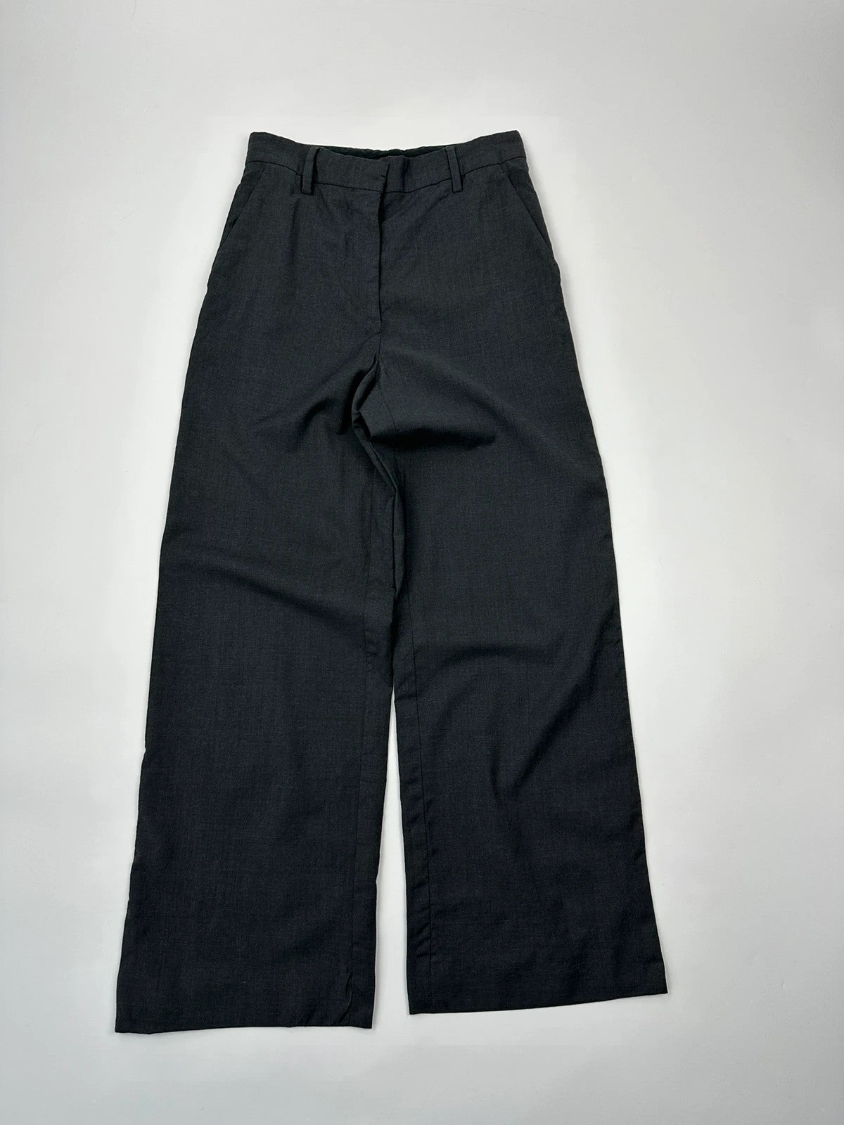 Prada grey wide-leg dress pants with subtle logo detail and luxurious wool material.