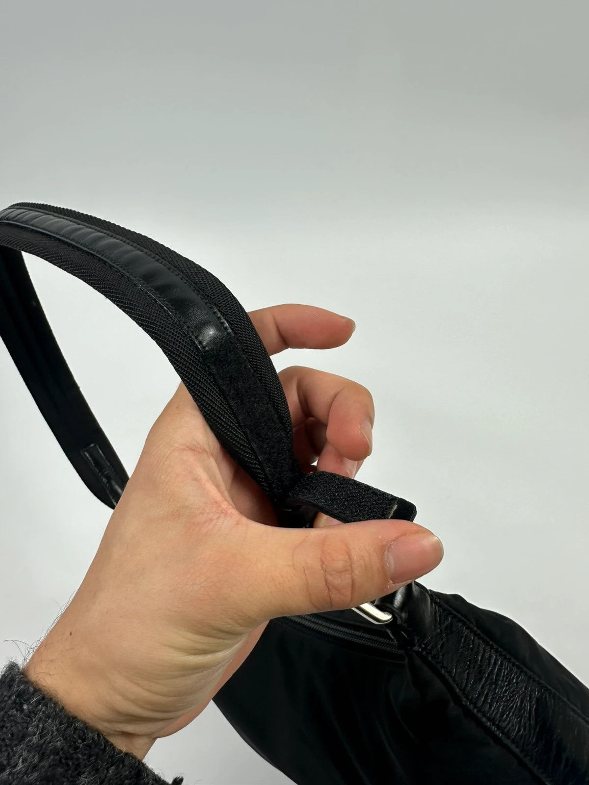 Prada black leather and nylon shoulder bag with logo detail and minimalist design.
