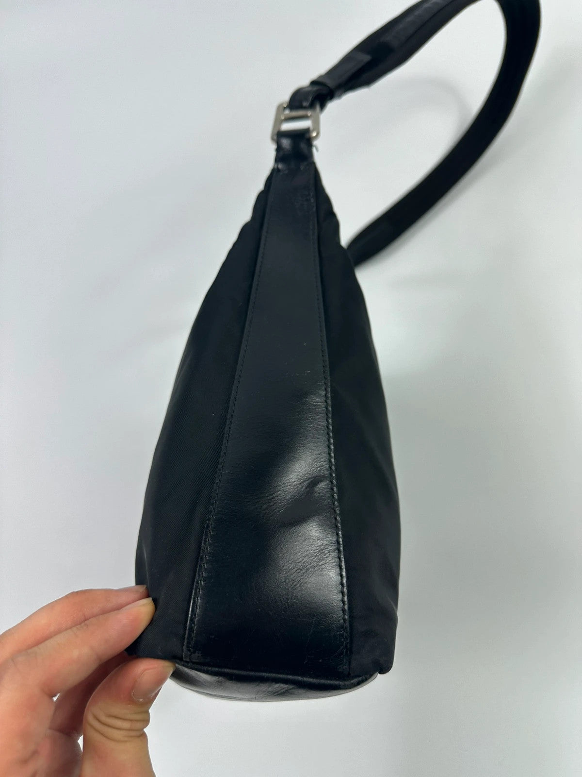 Prada black leather and nylon shoulder bag with logo detail and minimalist design.