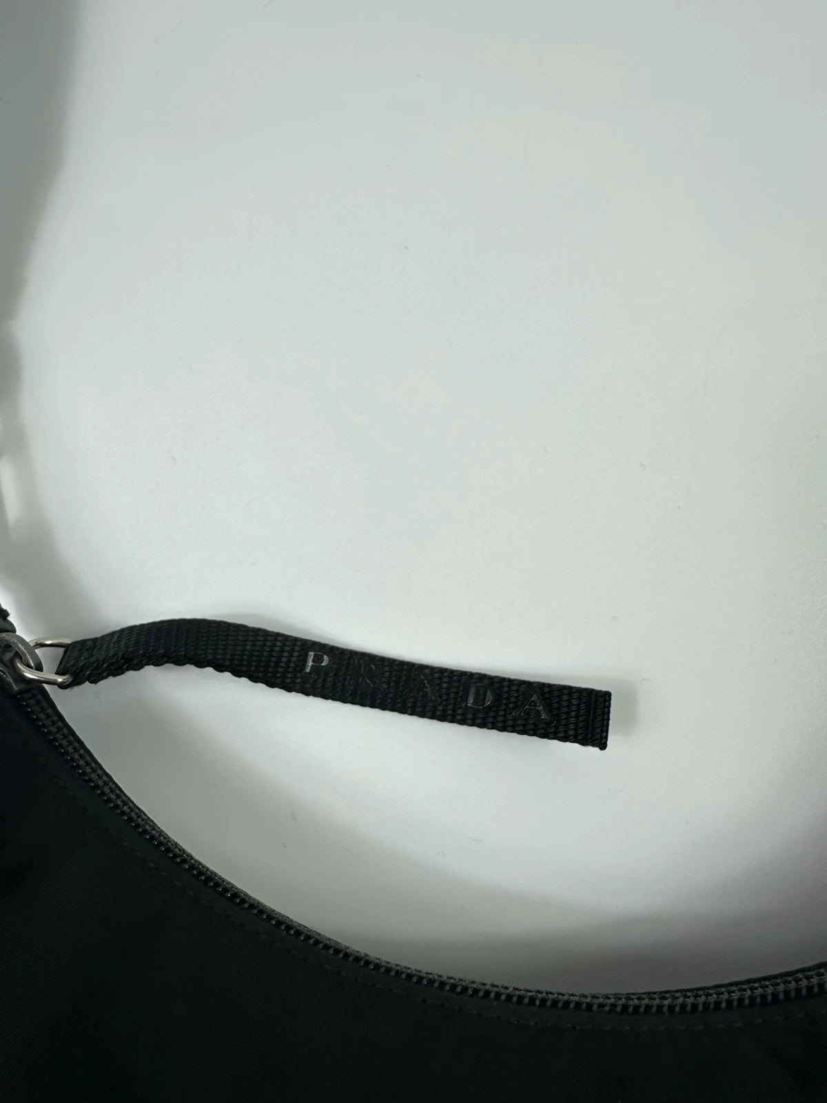 Prada black leather and nylon shoulder bag with logo detail and minimalist design.