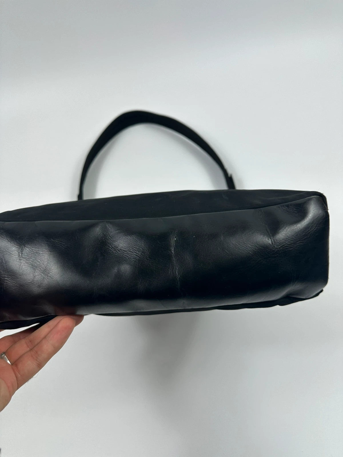 Prada black leather and nylon shoulder bag with logo detail and minimalist design.