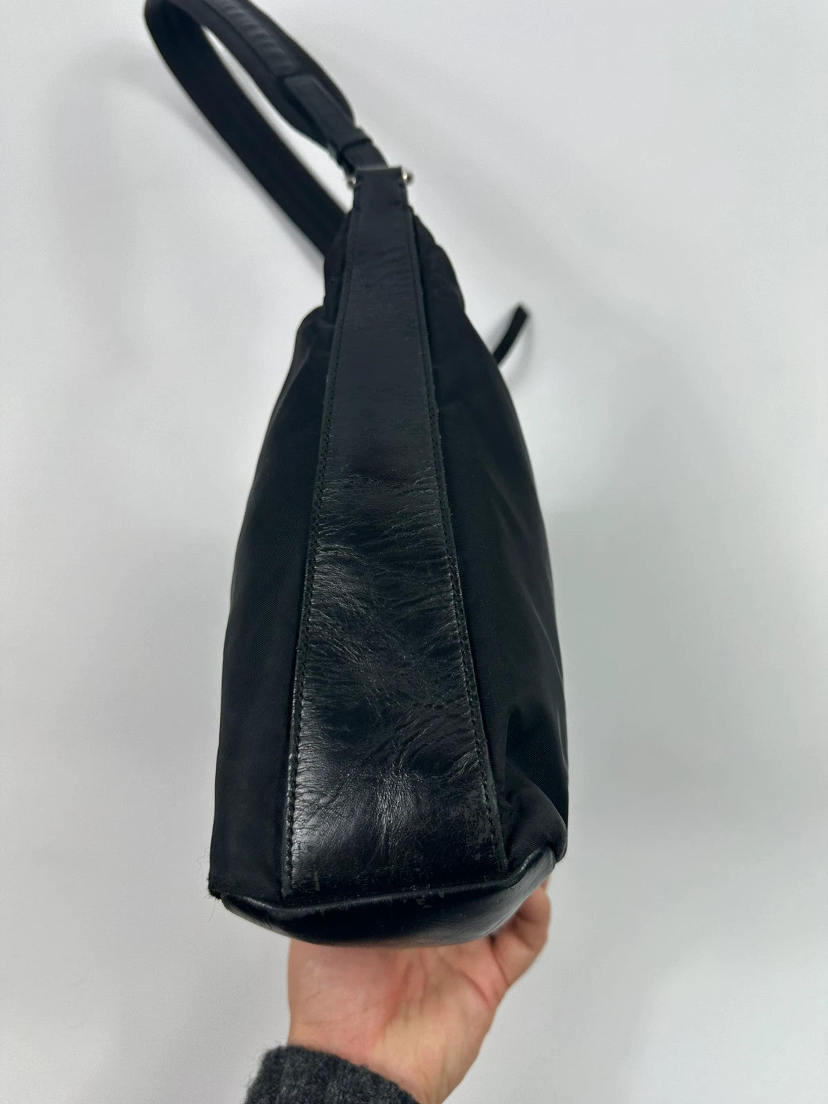 Prada black leather and nylon shoulder bag with logo detail and minimalist design.