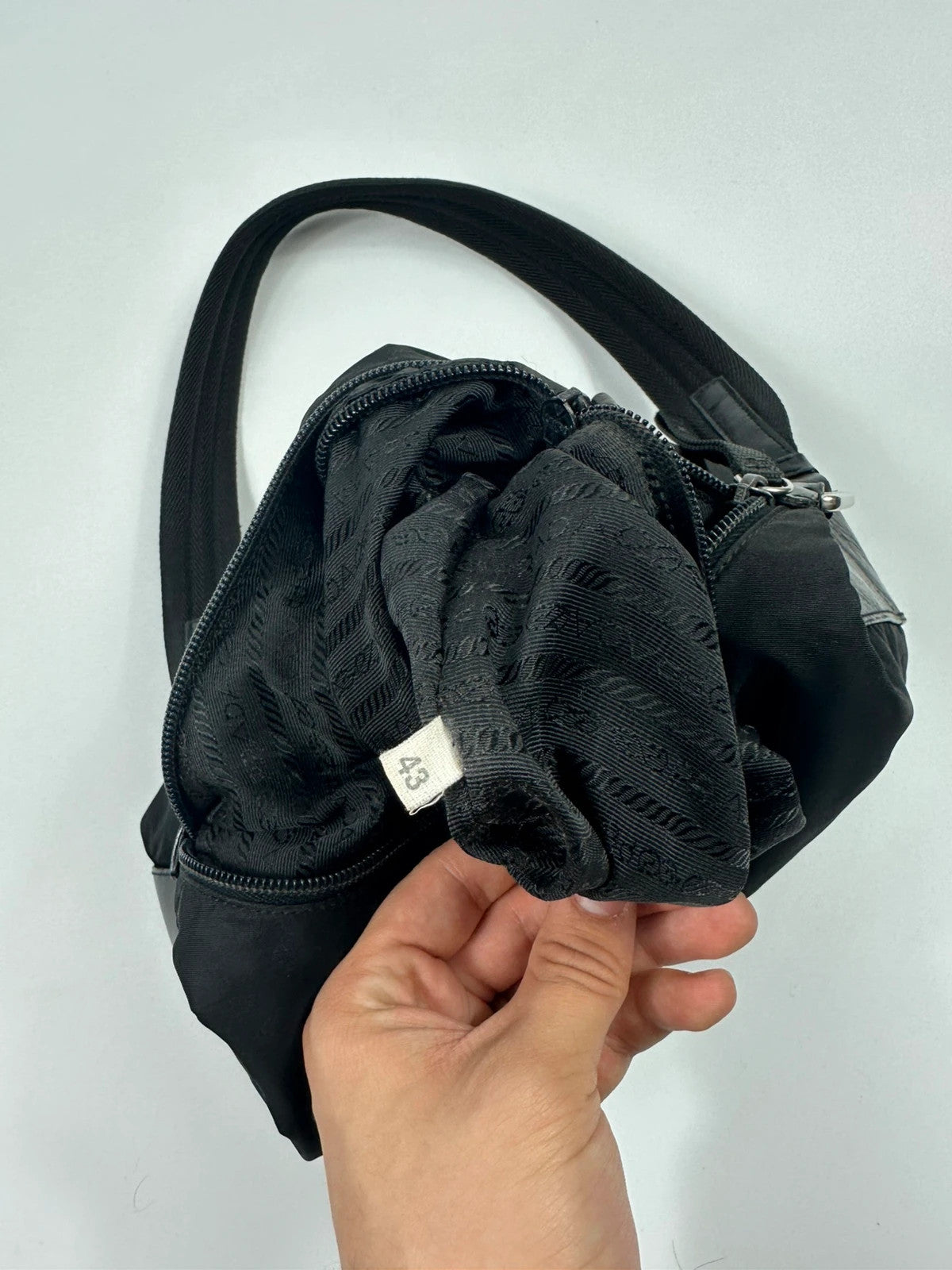 Prada black leather and nylon shoulder bag with logo detail and minimalist design.