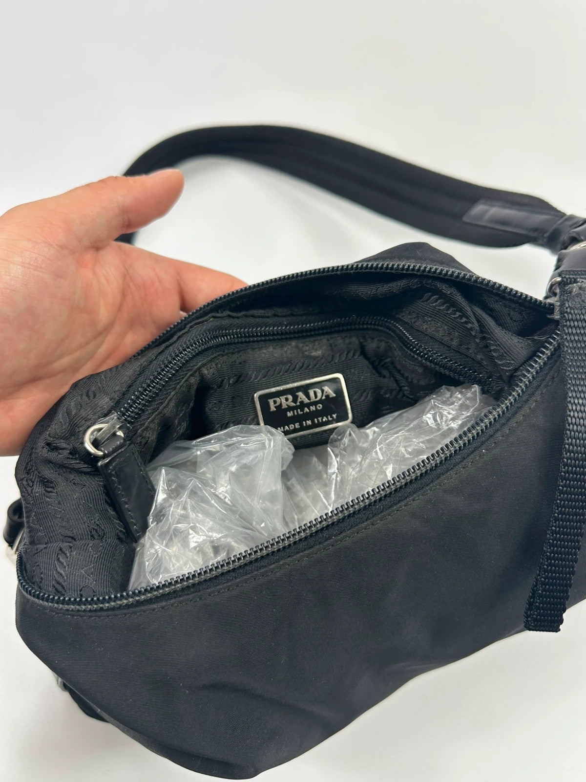 Prada black leather and nylon shoulder bag with logo detail and minimalist design.
