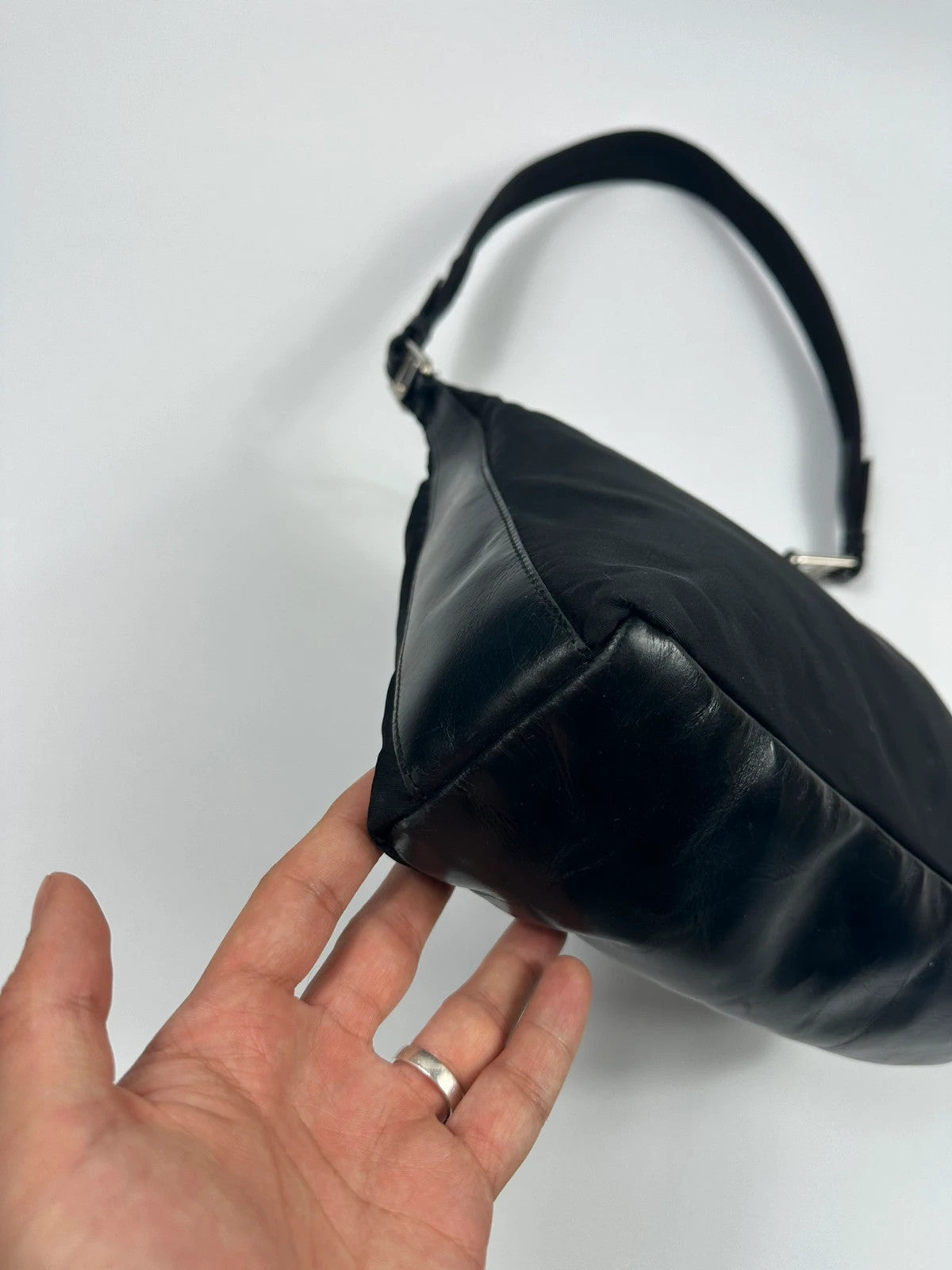 Prada black leather and nylon shoulder bag with logo detail and minimalist design.
