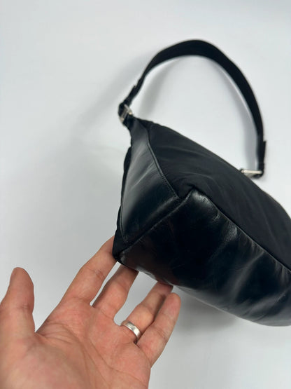 Prada black leather and nylon shoulder bag with logo detail and minimalist design.