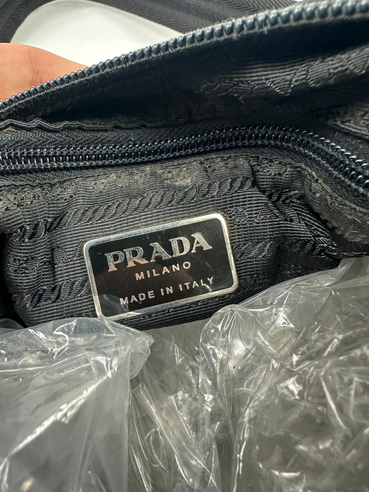 Prada black leather and nylon shoulder bag with logo detail and minimalist design.