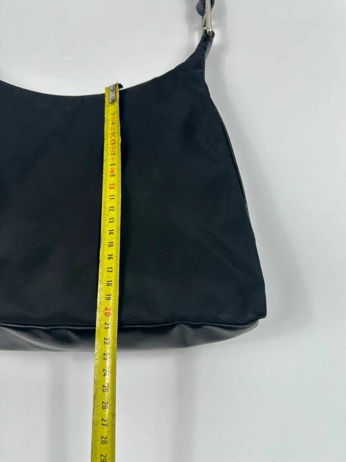 Prada black leather and nylon shoulder bag with logo detail and minimalist design.