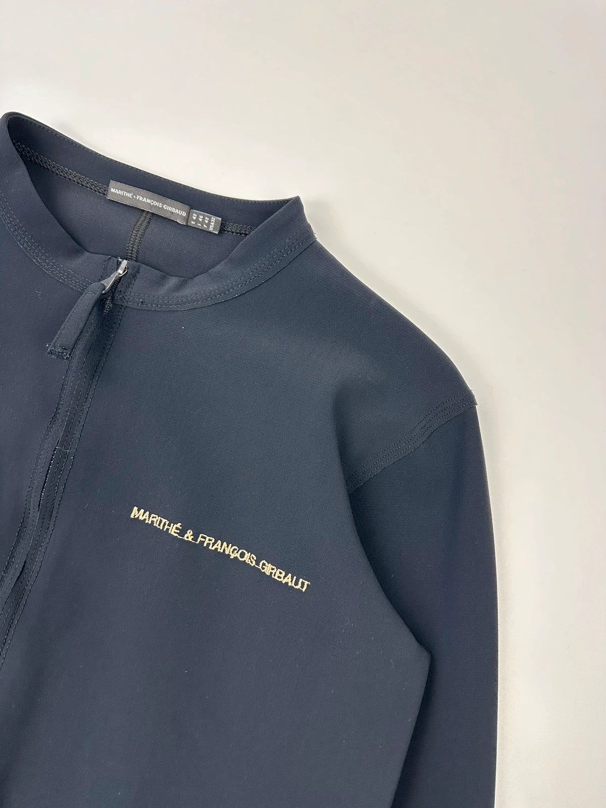Marithé Francois Girbaud navy jacket minimalist design with subtle branding and smooth fabric.