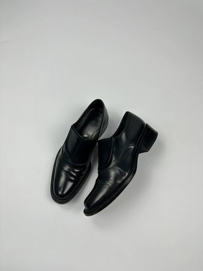 Prada black vernis loafers with pointy toe and subtle logo detailing.