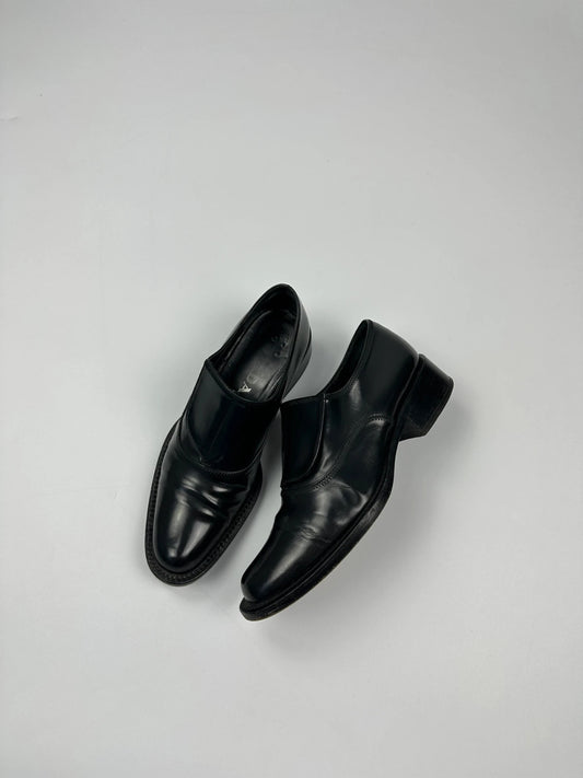 Prada black vernis loafers with pointy toe and subtle logo detailing.