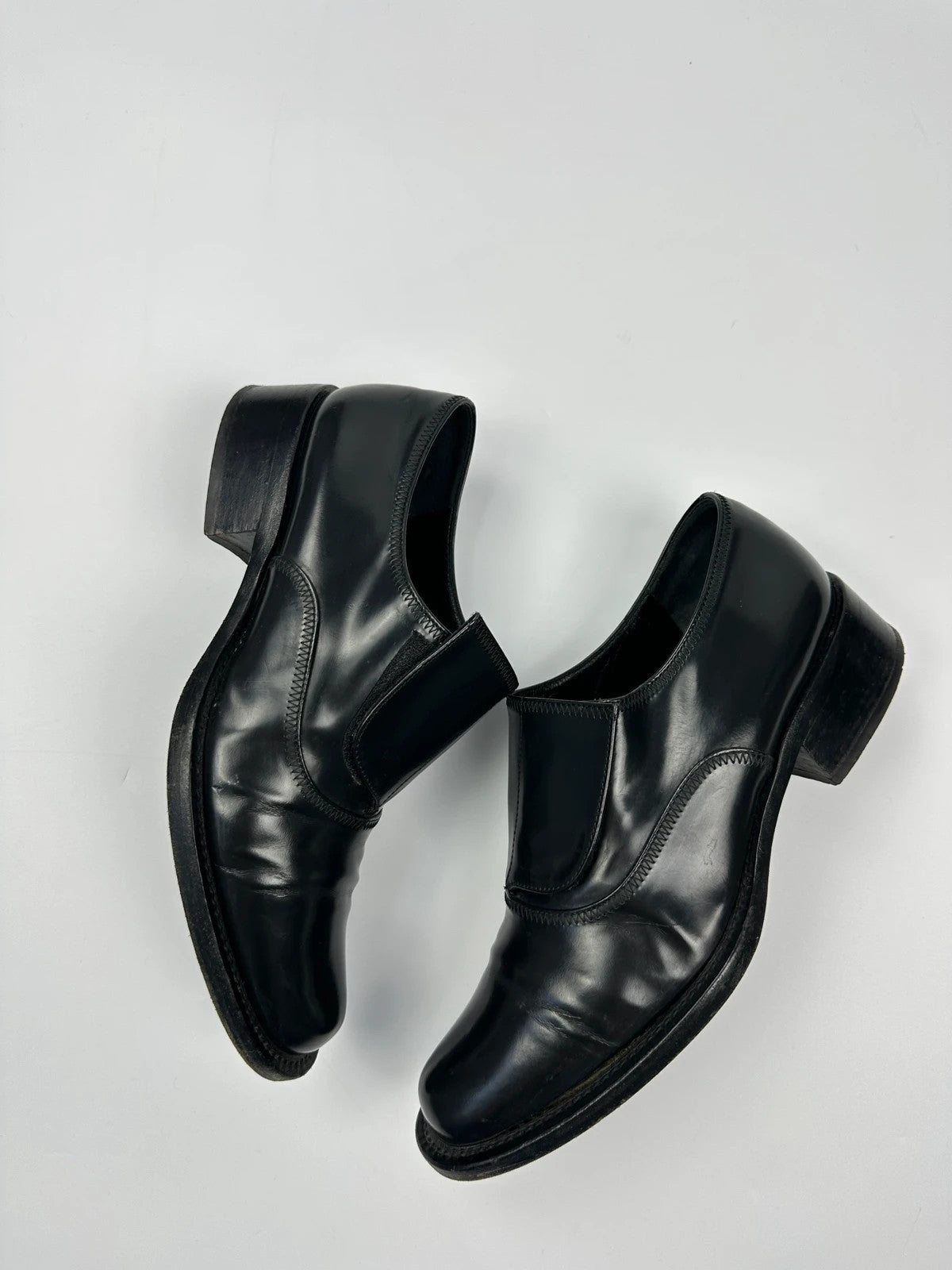 Prada black vernis loafers with pointy toe and subtle logo detailing.