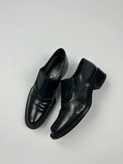 Prada black vernis loafers with pointy toe and subtle logo detailing.