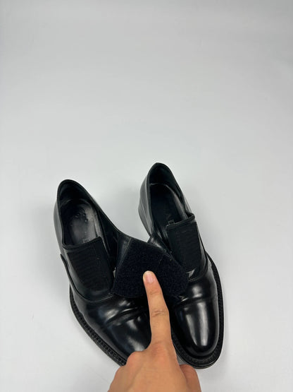 Prada black vernis loafers with pointy toe and subtle logo detailing.
