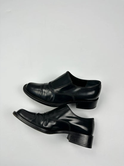 Prada black vernis loafers with pointy toe and subtle logo detailing.