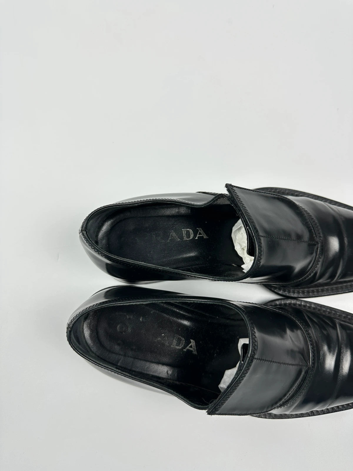 Prada black vernis loafers with pointy toe and subtle logo detailing.