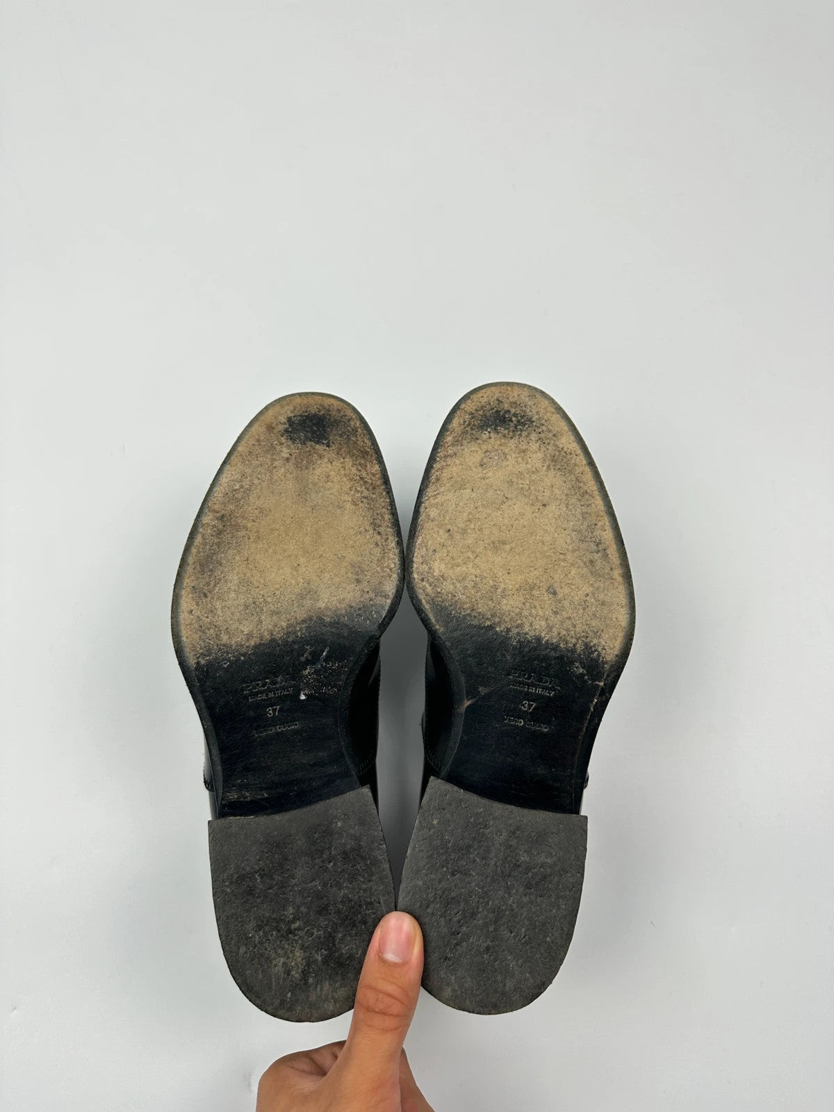 Prada black vernis loafers with pointy toe and subtle logo detailing.